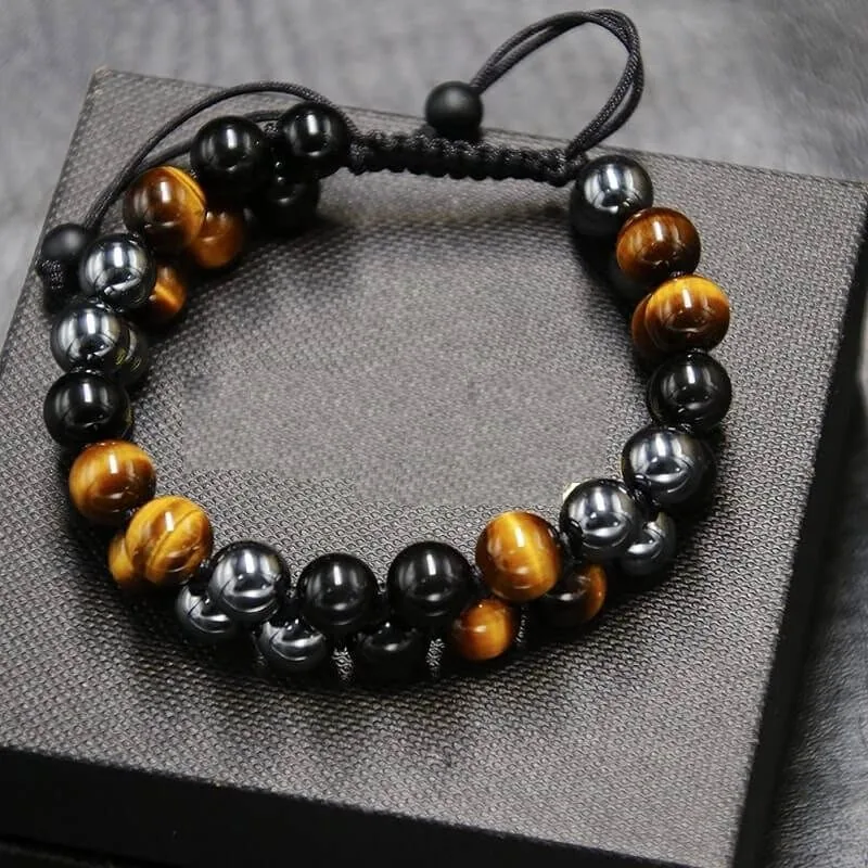 Black obsidian and tiger eye bead bracelet on a dark textured display block