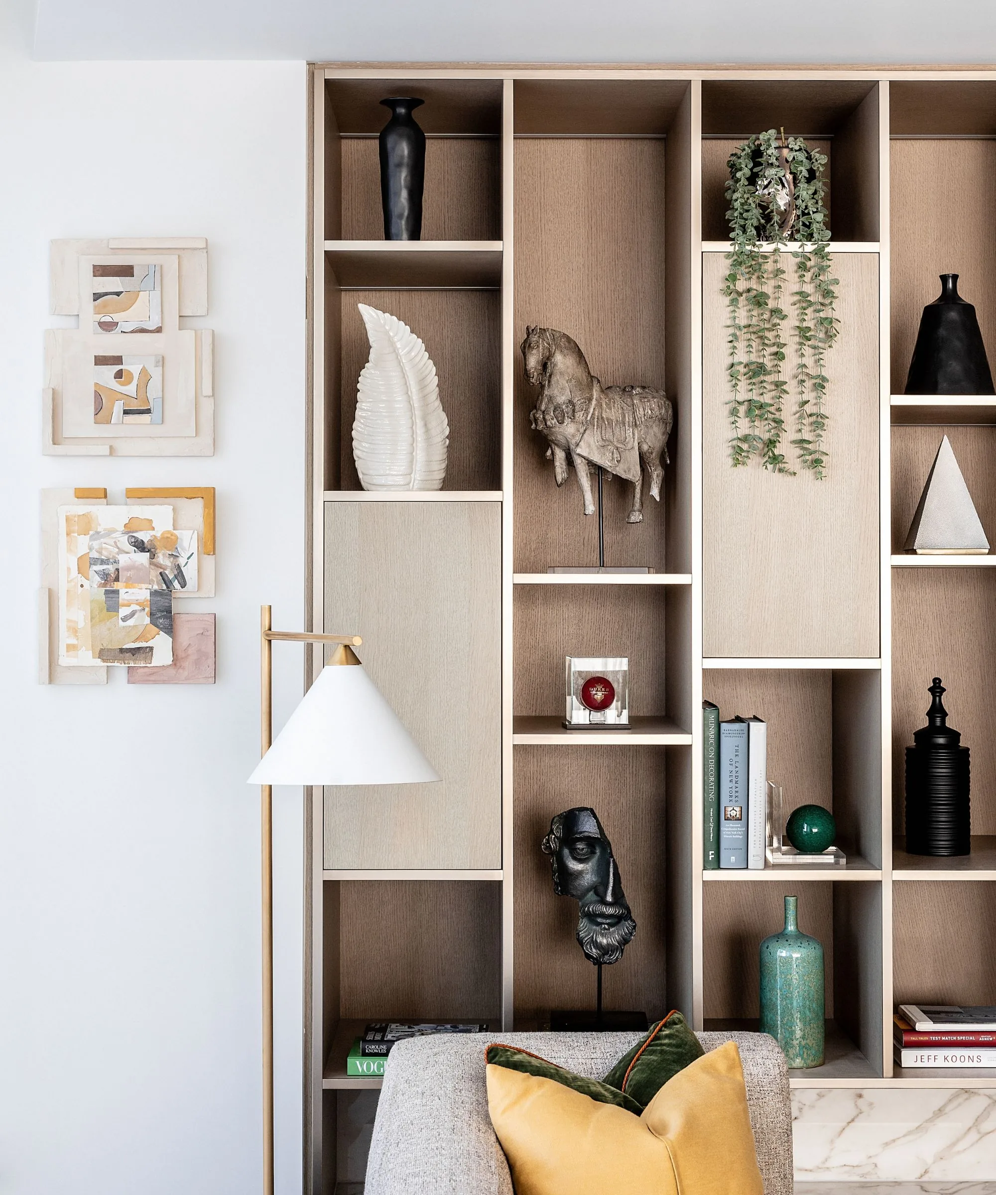 Tall open shelving with edited decor, fewer objects, and a calmer living room corner