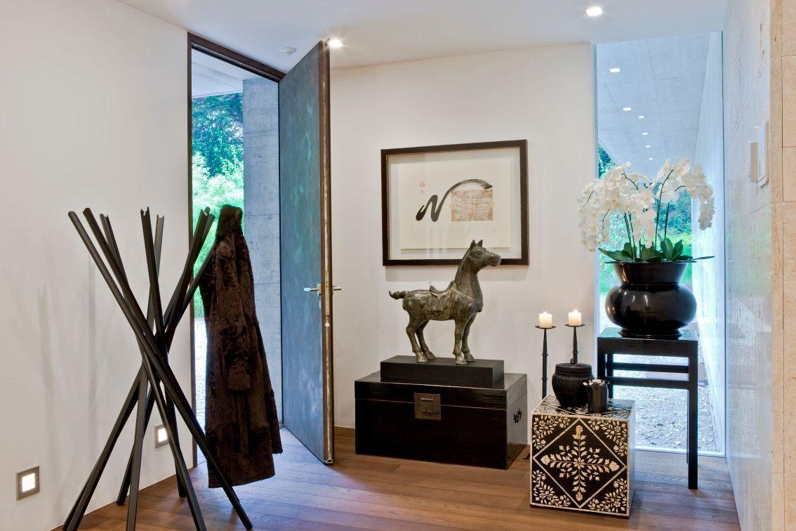 Maintained entry with an open door, orchids, candles, and one symbolic horse figure