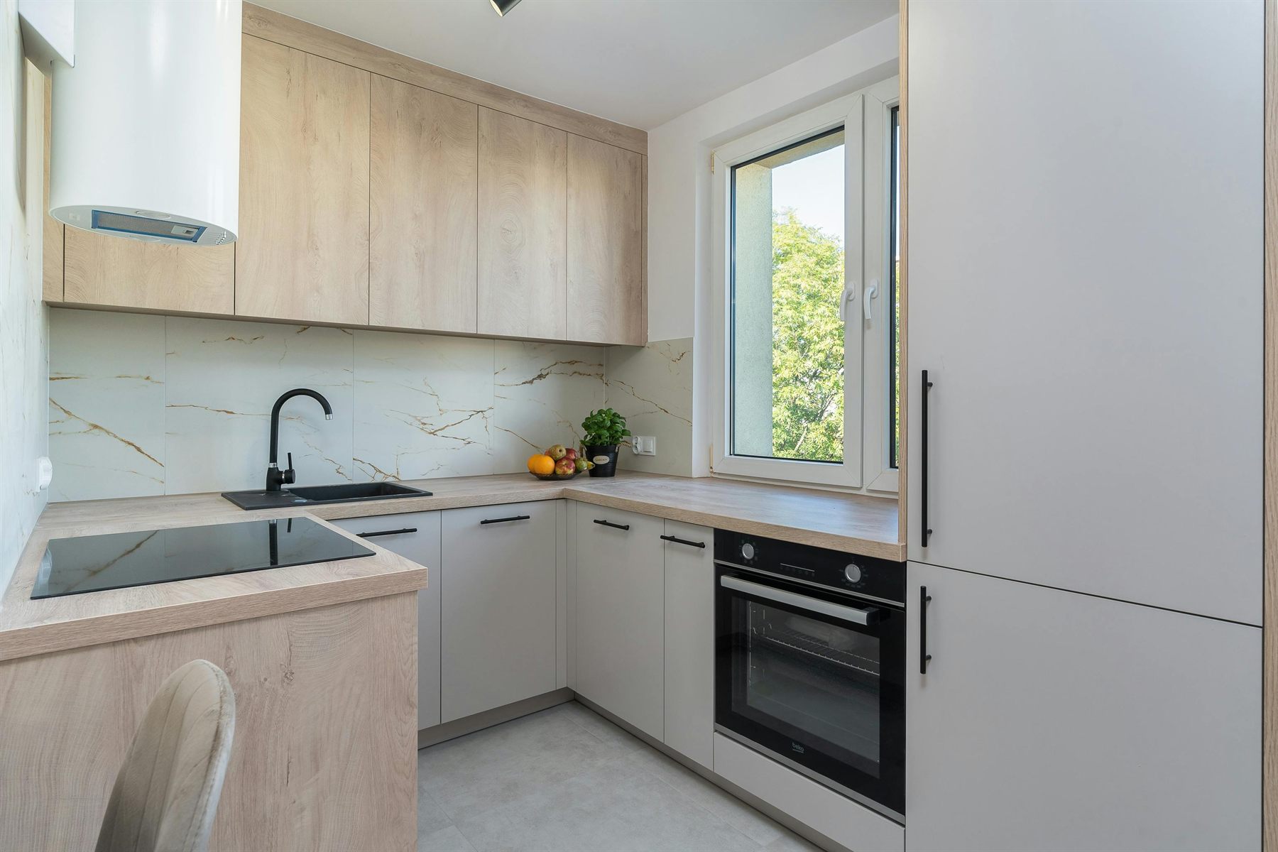 Kitchen with light wood cabinets, pale counters, and a fresh warm palette