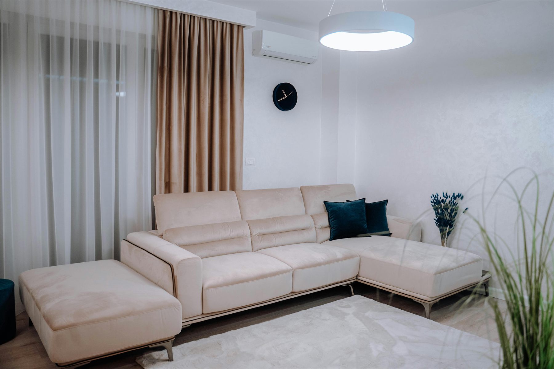 Quiet neutral living room with cream walls, soft curtains, and lower visual contrast