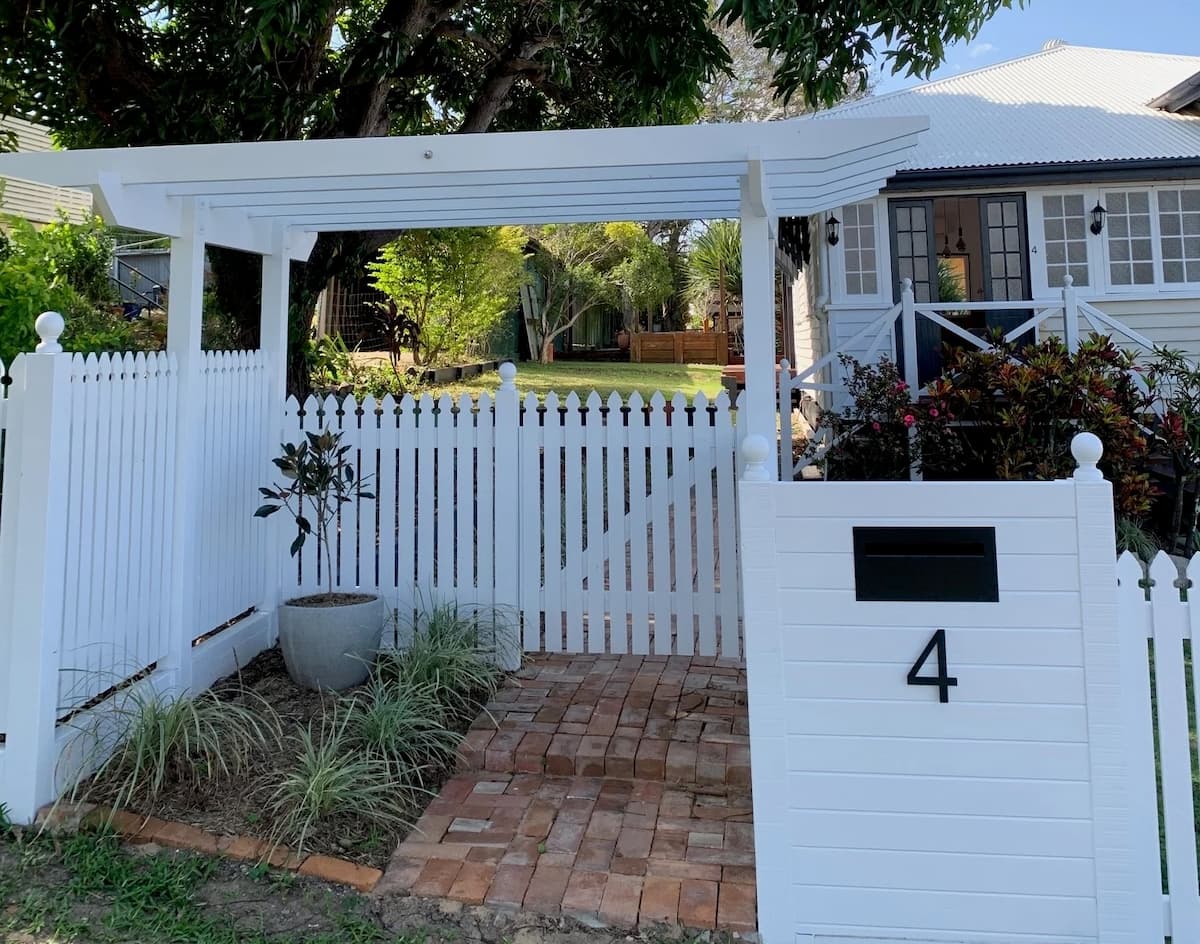 White garden gate and entry path with a bold single house number displayed clearly