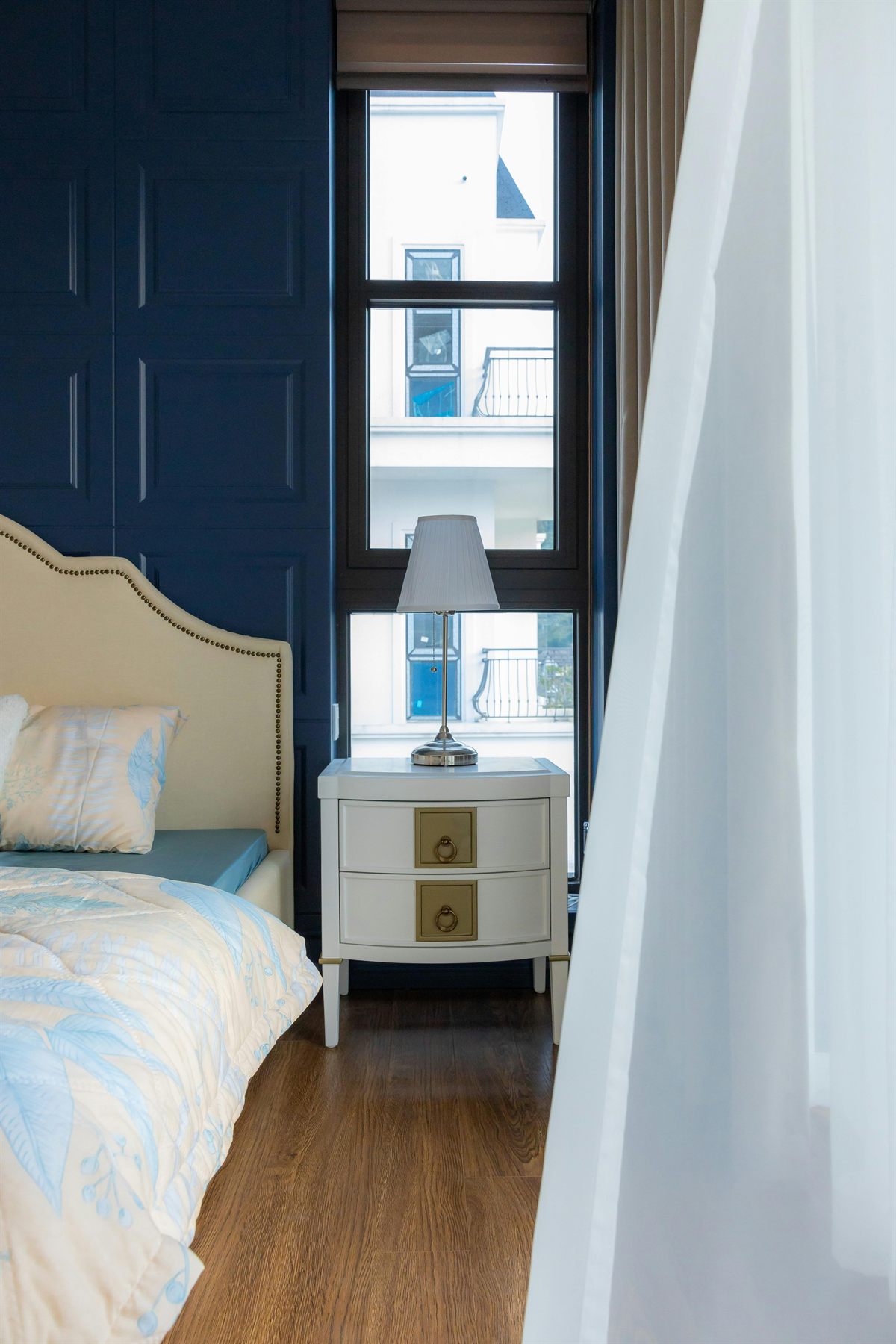 Bedroom with blue accents, pale walls, and soft natural light