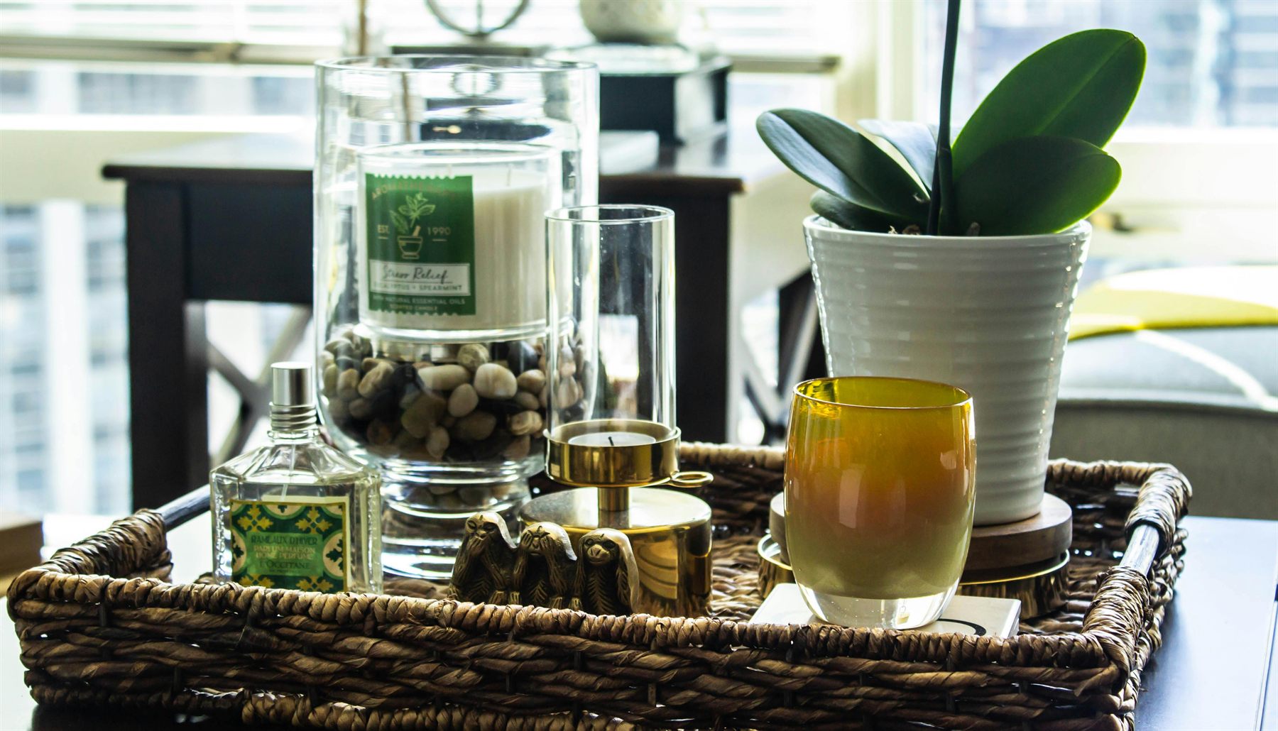 Woven tray with candle, plant, and a few edited decor items