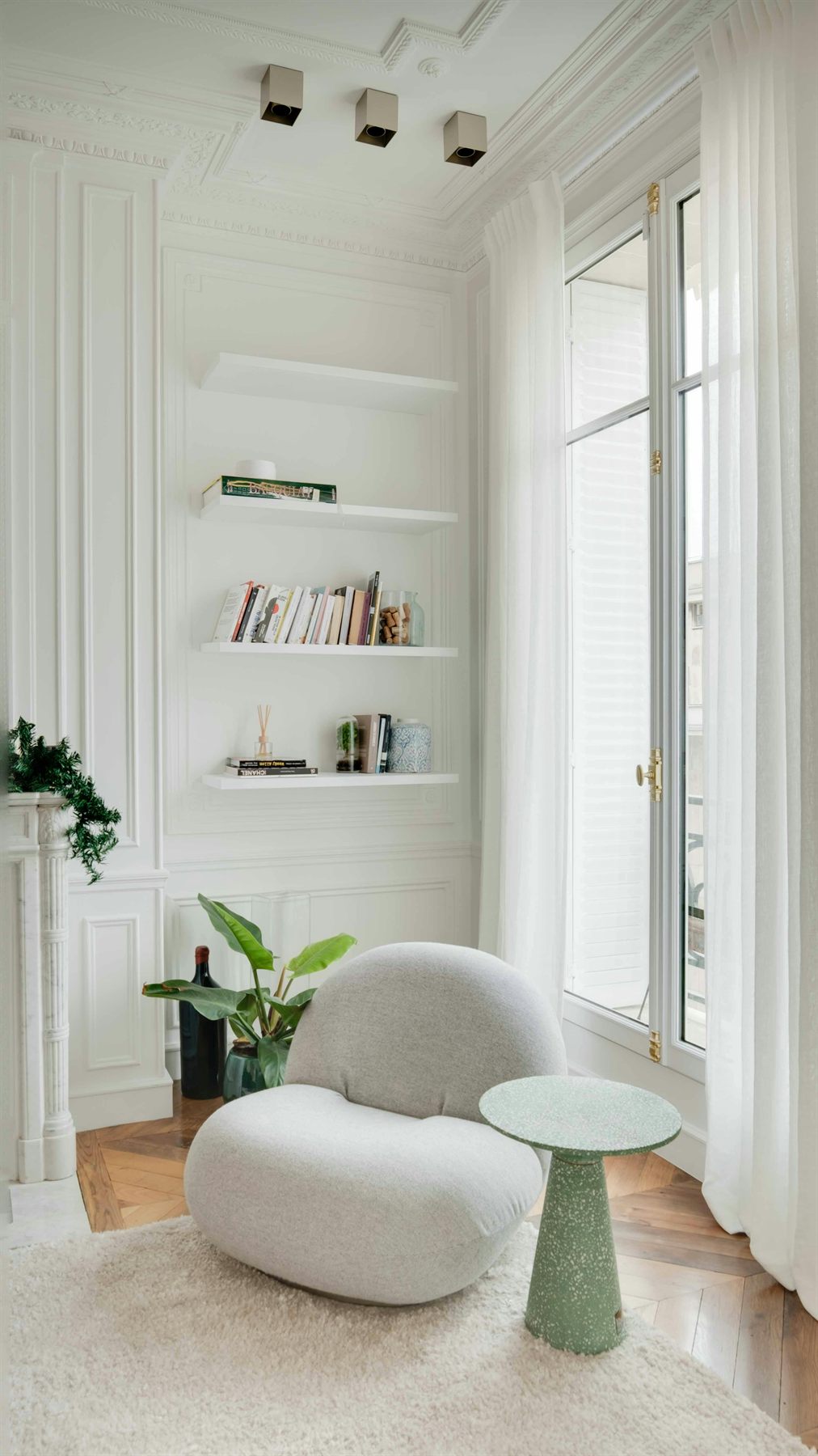 White room with green accents and natural wood details